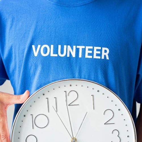 Close up of a person wearing a blue t-shirt with the word VOLUNTEER on it.
