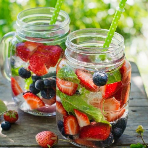 Two glasses with strawberry, blueberry, and mint infused water