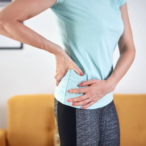 Profile of another woman holding her lower back and hip