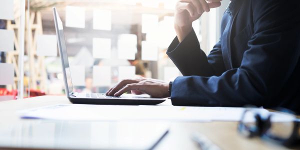 Person using a laptop at a desk in an office.