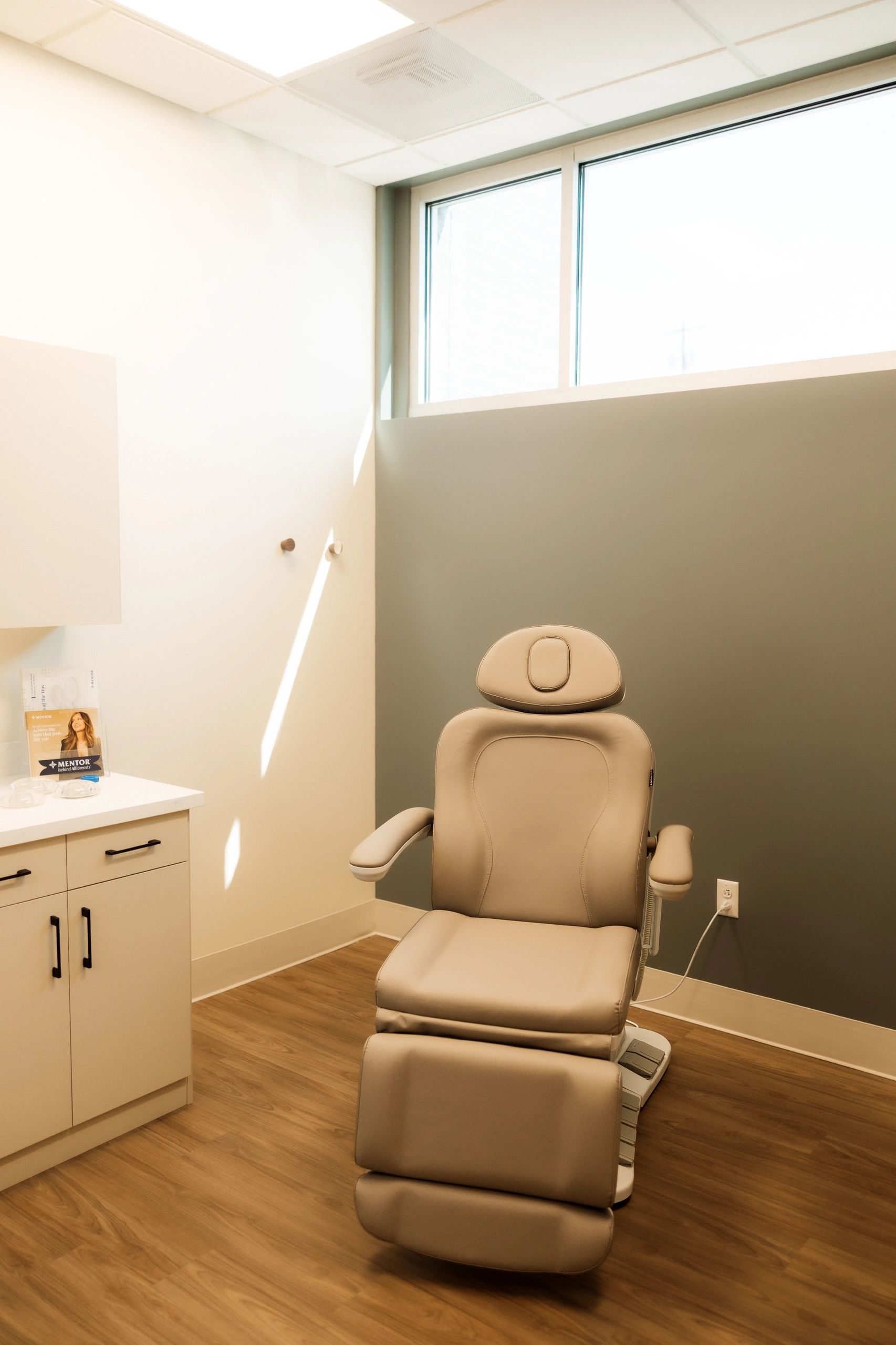 A modern, comfortable beige medical chair in a clean clinic room.