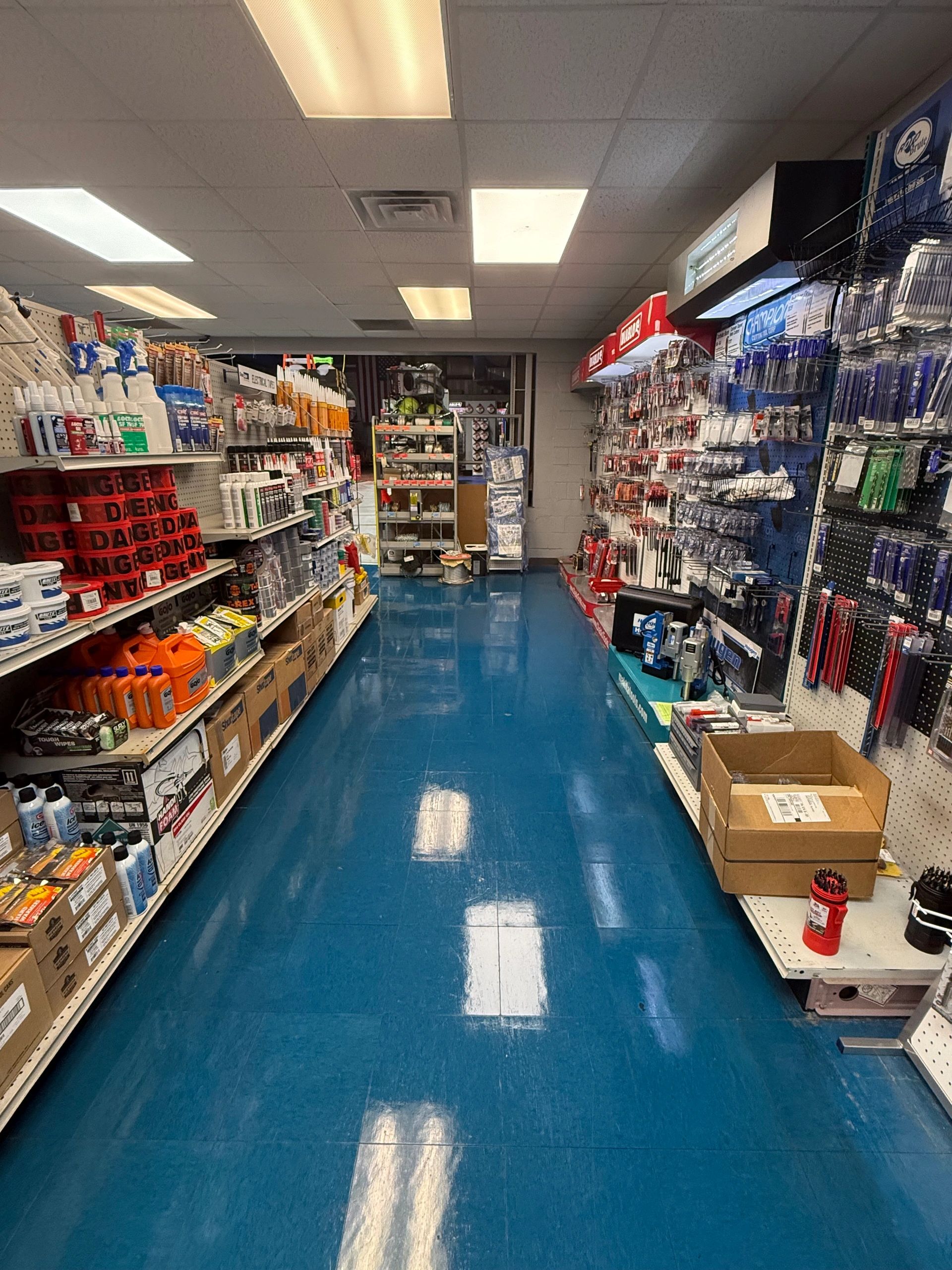 A hardware store aisle with various tools and supplies.