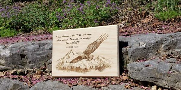 Wood burning techniques of a bald eagle with a mountain in the background. 