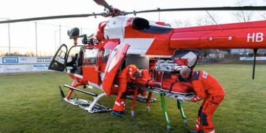 Rescue team loading a patient into a helicopter.