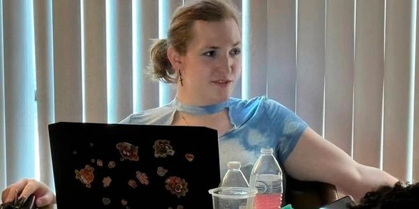 Image features Lexi Woods (She/They/It) Member of the Board