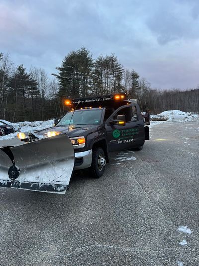 Twin River Landscaping work vehicle with a snow plow attached to the front. 
