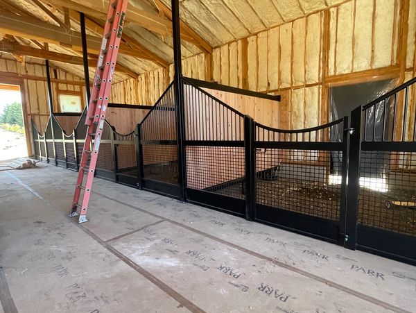 Indoor horse stalls under construction with insulation.