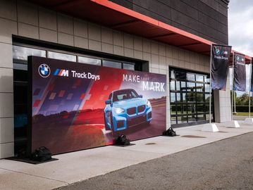 BMW M Track Days promotional display with a blue car image.