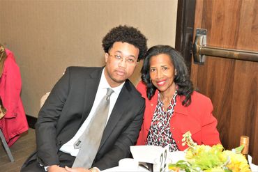 Two people sitting at table and smiling.