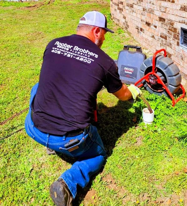 Running Sewer cable down the clean out to clear a main line stoppage.