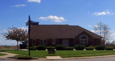A brick building under a blue sky with a street sign in front.
