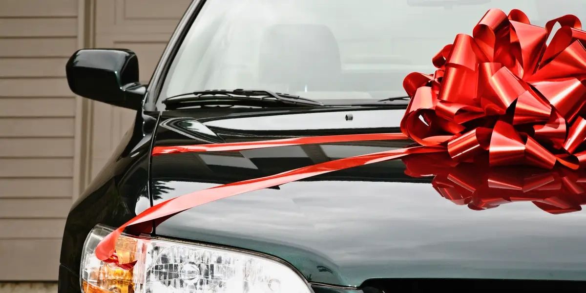 a black car with a red bow on the hood