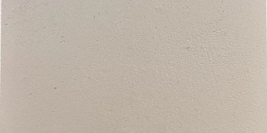 Mur beige texturé avec quelques marques.