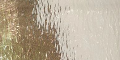 Texture en verre givré avec zones dorées et blanches.