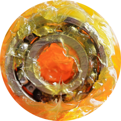 Close-up of a ball bearing covered in yellow grease.