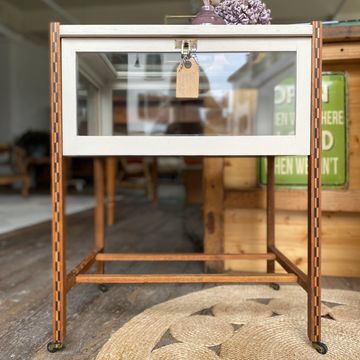 Wood and glass display case on metal legs with a tag.
