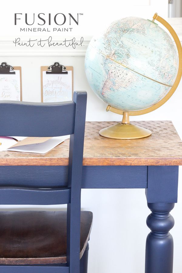 A navy blue painted chair and table with a globe on top and inspirational clipboards in the background.