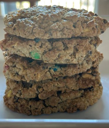 A stack of thick, chunky oatmeal cookies with colorful candy pieces.