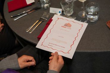 Person holding a dinner menu at a table.