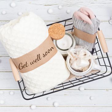 Get well soon gift basket with cozy items and angel figurines.
