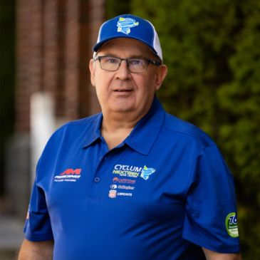 Man in blue sportswear with glasses and cap.