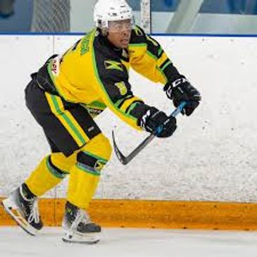 Ice hockey player in yellow and green uniform skating on ice rink.