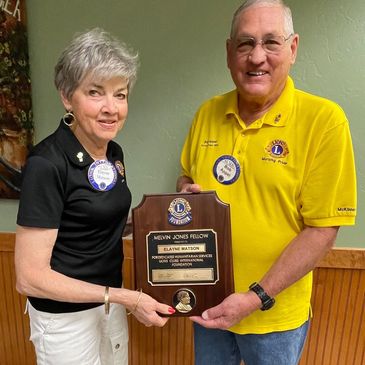 Lion Elayne Matson receives the Melvin Jones Fellowship from Lion President and PDG Bob Appel. The M