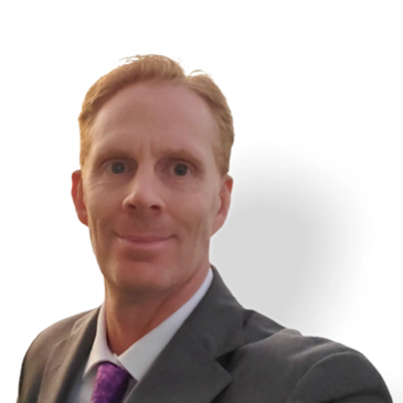 Man in suit with purple tie looking at camera.