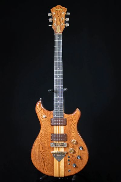 Vintage Ibanez electric guitar with natural wood finish on black background.