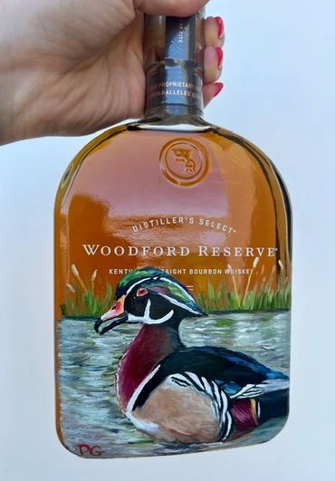 Hand-painted Woodford Reserve bottle featuring a colorful duck illustration.