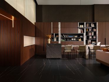 Modern dining area with dark wood paneling and sleek furniture.