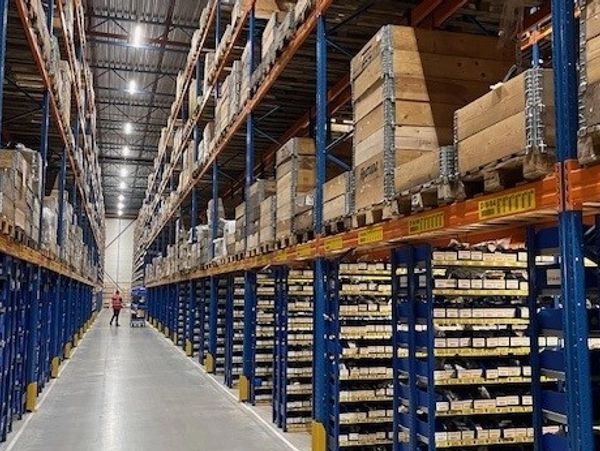 Large warehouse aisle with tall shelves filled with boxes and goods.
