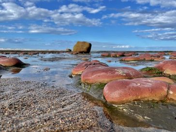 View of the sea and clouds including pebbles and sand.