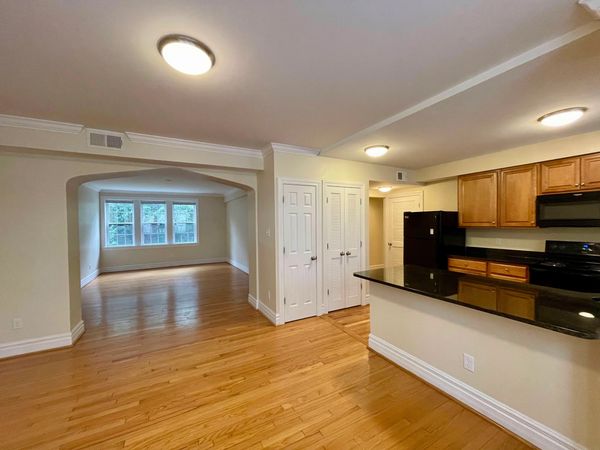 Spacious open-concept living area with wooden floors and modern kitchen.
