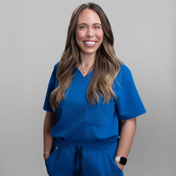 Smiling woman in blue medical scrubs.