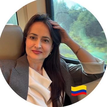 A woman with long dark hair sitting by a train window, with a Colombian flag emoji.
