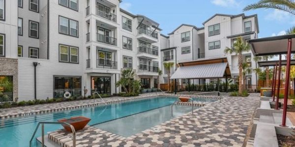 Modern apartment complex with a clean outdoor pool and patterned deck.