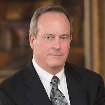 Professional portrait of a middle-aged man in a suit and tie.
