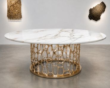 Elegant round table with a white marble top and gold intricate base.
