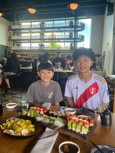 Two boys enjoying a sushi meal in a restaurant.