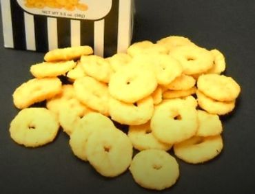 A pile of round, ring-shaped butter cookies on a black surface.