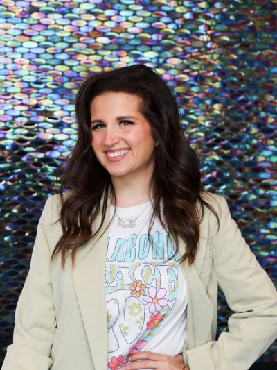 Young woman smiling in front of a colorful backdrop.