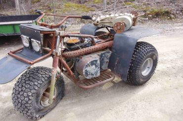 Custom-built three-wheeled vehicle with large rear tires.