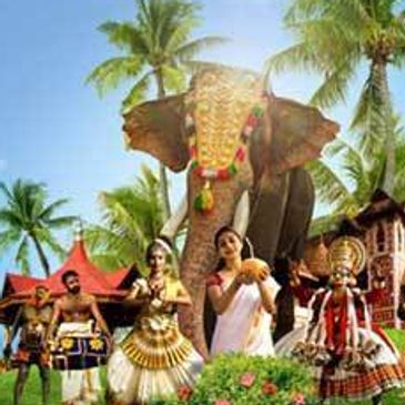 Traditional Kerala cultural dancers perform with a decorated elephant in the background.