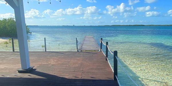 A dock with a walkway down into bright blue tropical water.