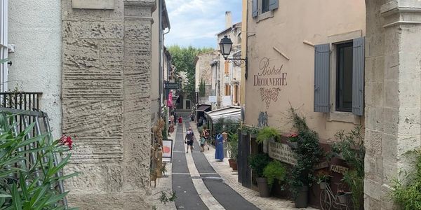 A narrow street leading down a hill, surrounded on both sides by old buildings