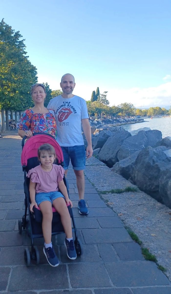 famiglia felice lungo il Lago di Garda con mamma, papà e figlia in passeggino