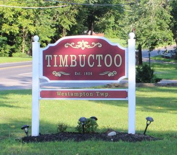 A red and white sign marking Timbuctoo, established 1826, in Westampton Township.
