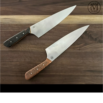 Two chef knives with distinct wooden handles on a wooden surface.