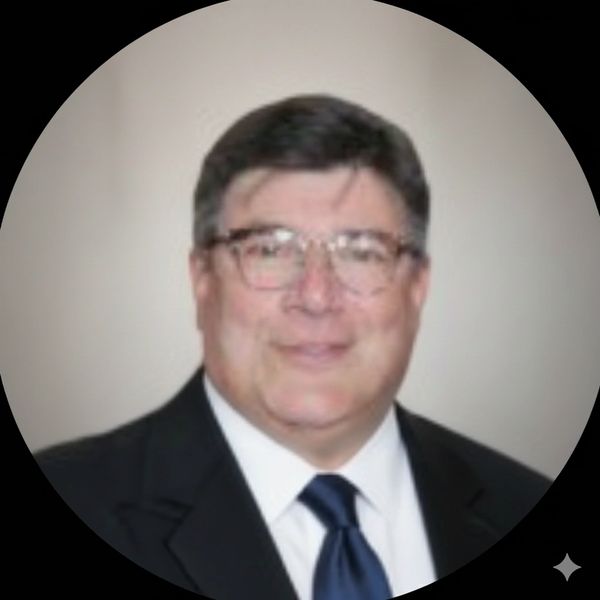Portrait of a man in a suit and tie with glasses.